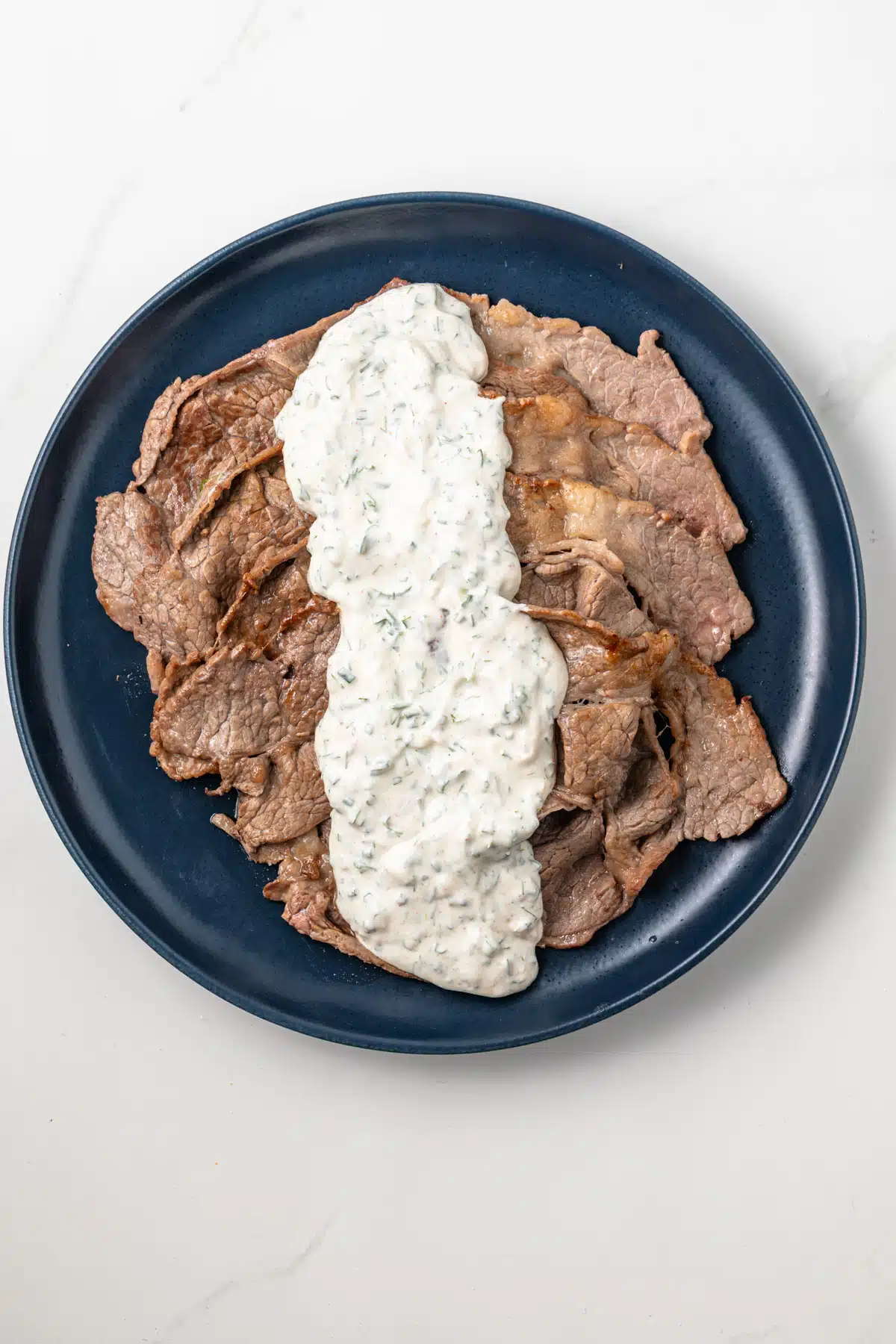 Creamy herb sauce spread over thin sliced beef.