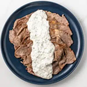 Creamy herb sauce spread over thin sliced beef.
