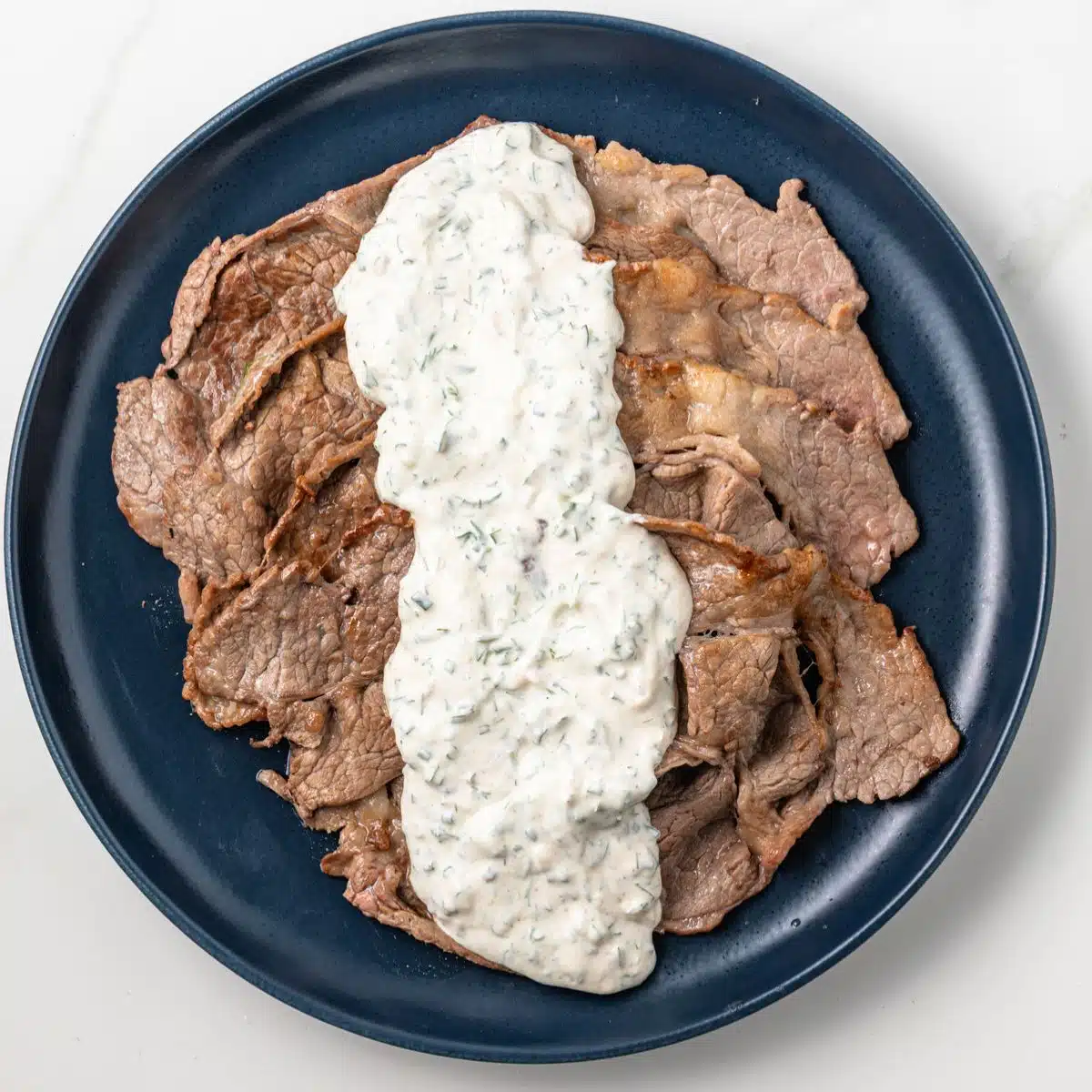 Creamy herb sauce spread over thin sliced beef.