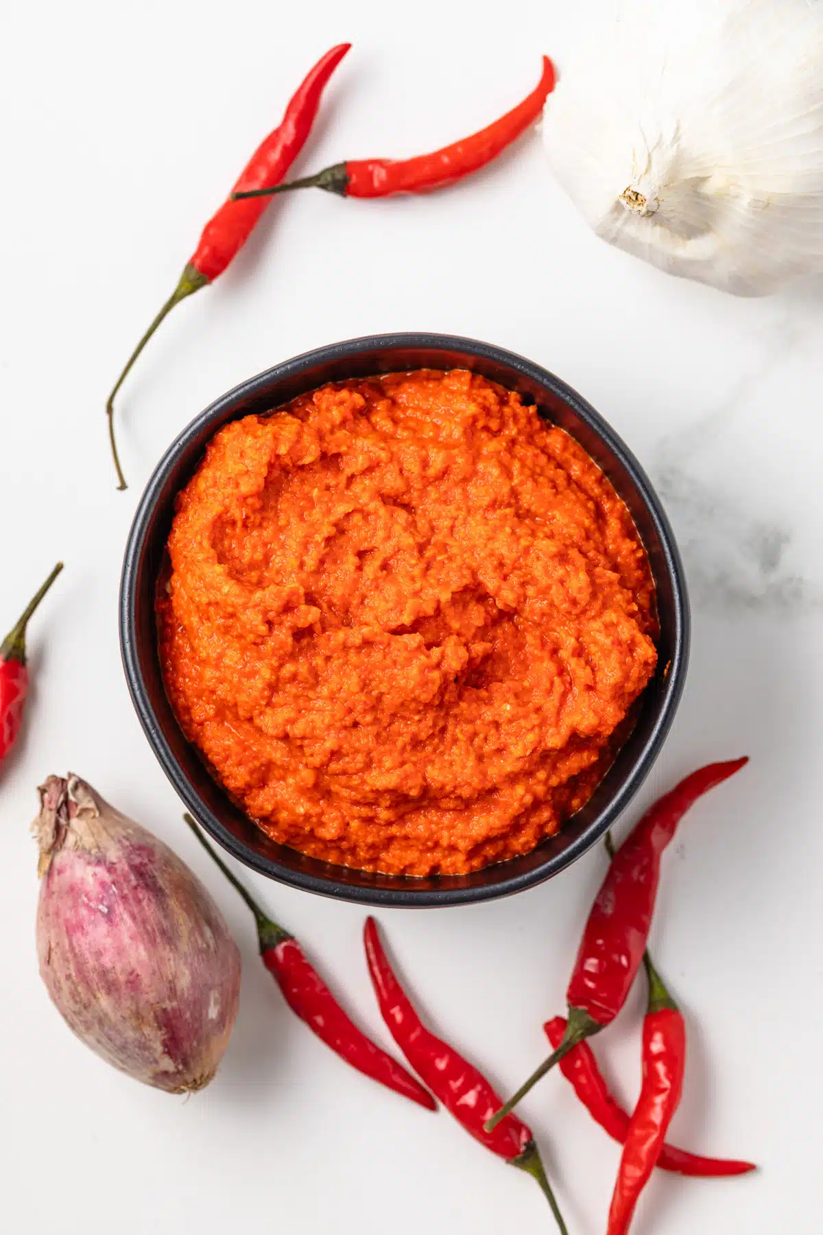 Overhead view of homemade sambal oelek in a black bowl.