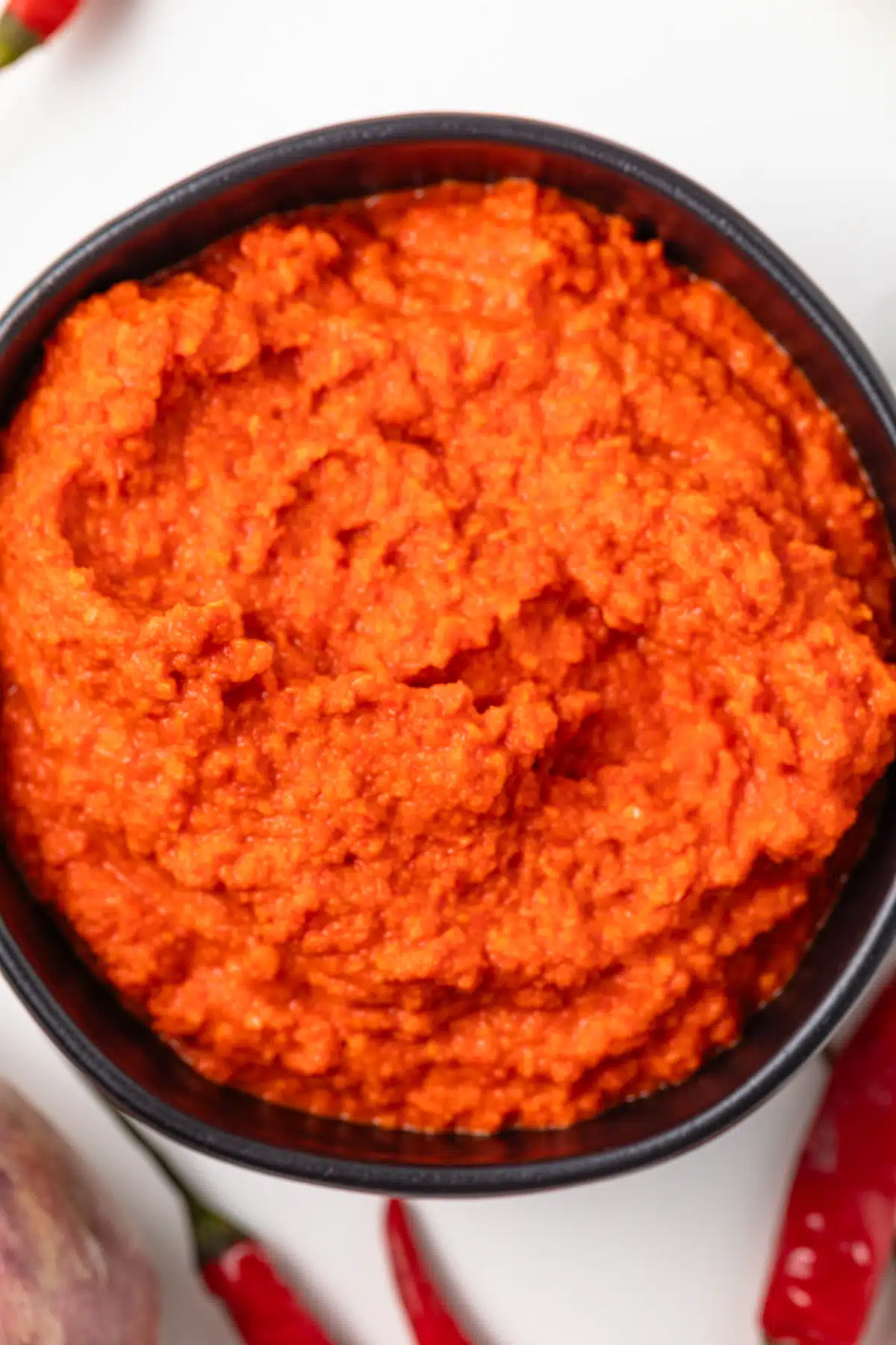 Overhead view of homemade sambal oelek in a black bowl.