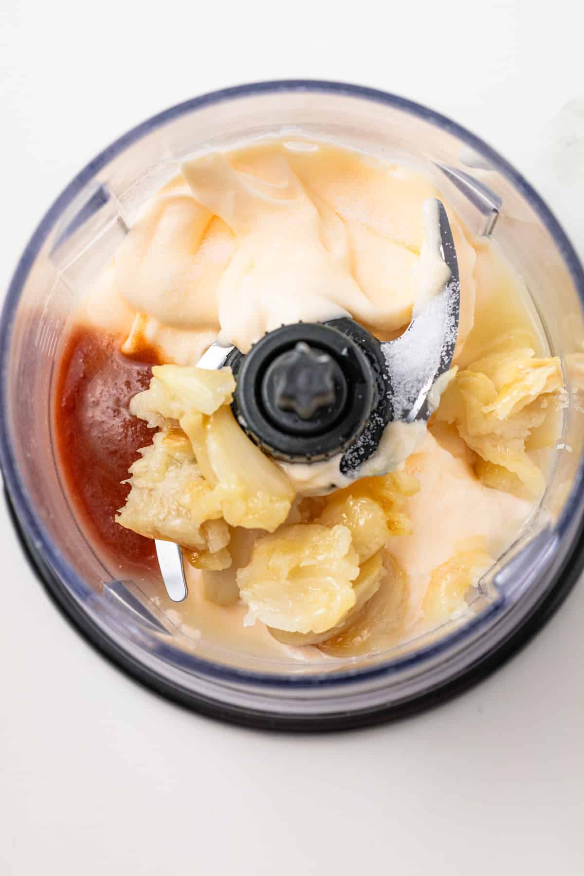 Ingredients for aioli in a food processor.