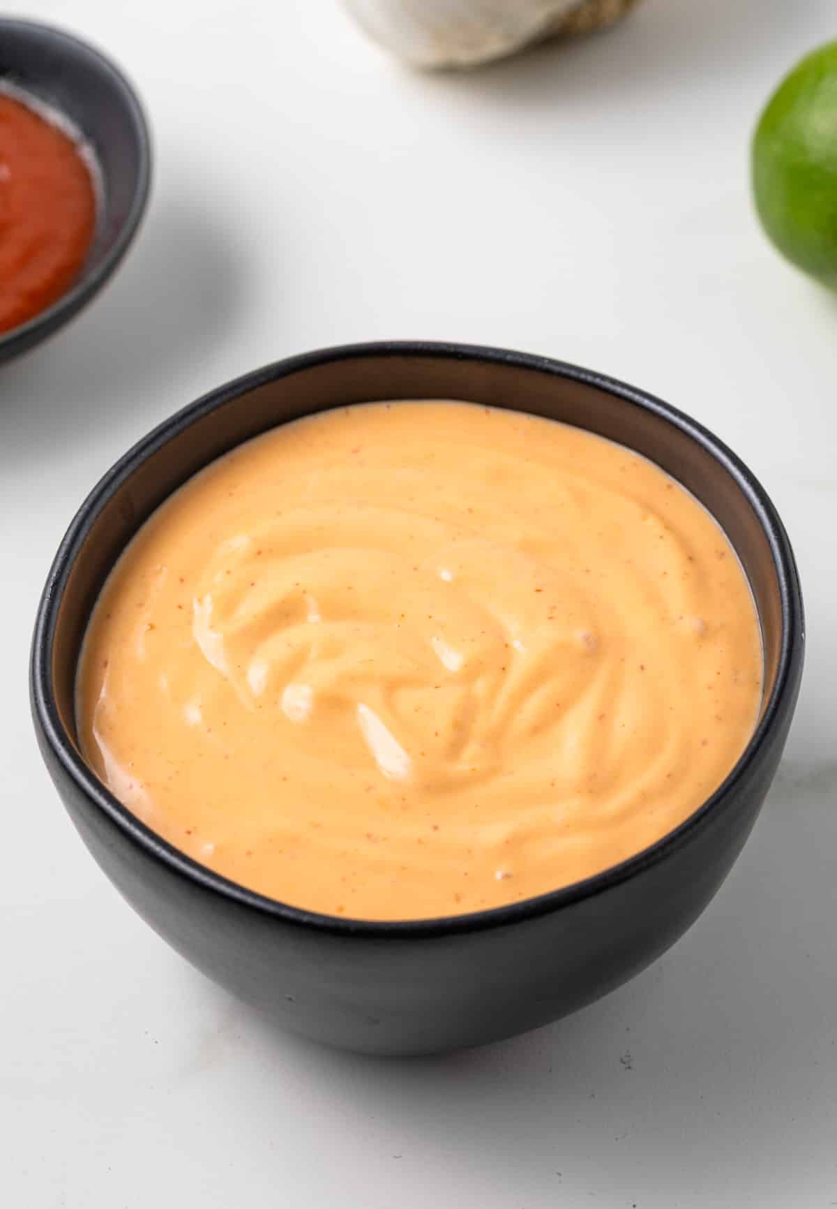 Side view of sriracha aioli in a bowl.