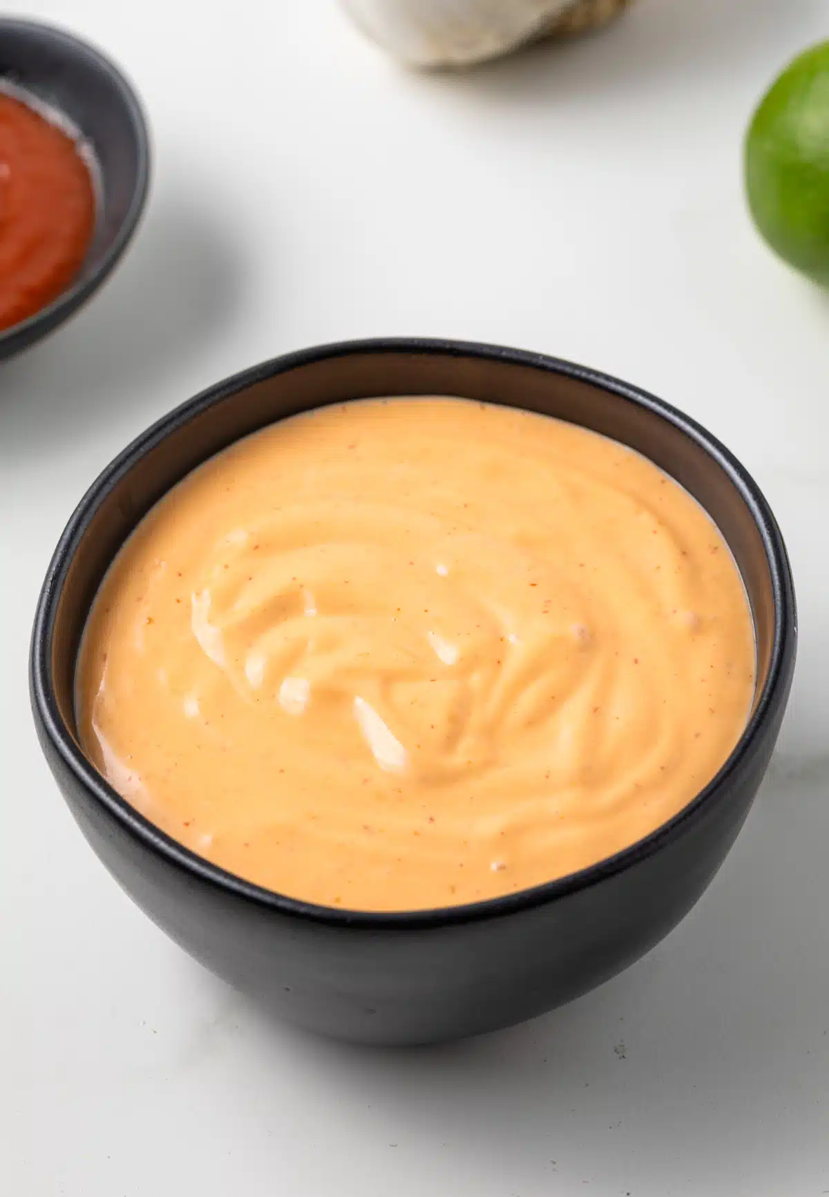 Side view of sriracha aioli in a bowl.