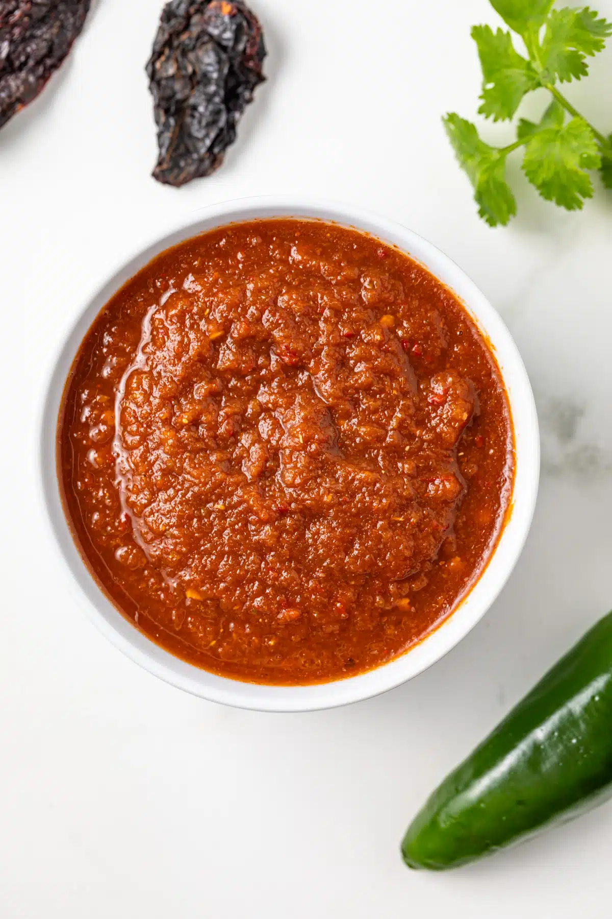 Overhead of homemade picante sauce in a white bowl.
