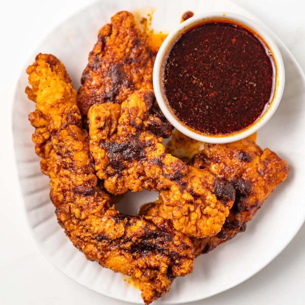 Chicken tenders with a side of Nashville hot sauce.