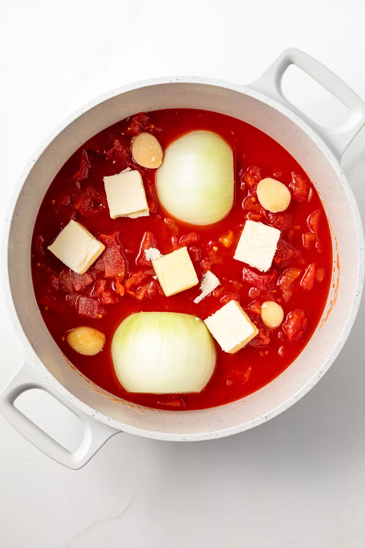 Tomatoes with onions and butter in a saucepan.