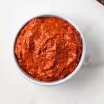 Overhead view of harissa paste in a white bowl.