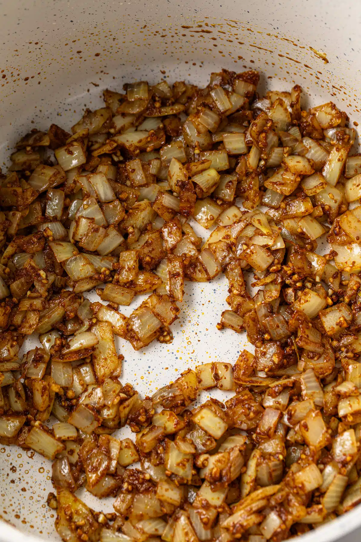 Sauteed onions with spices in a pot.