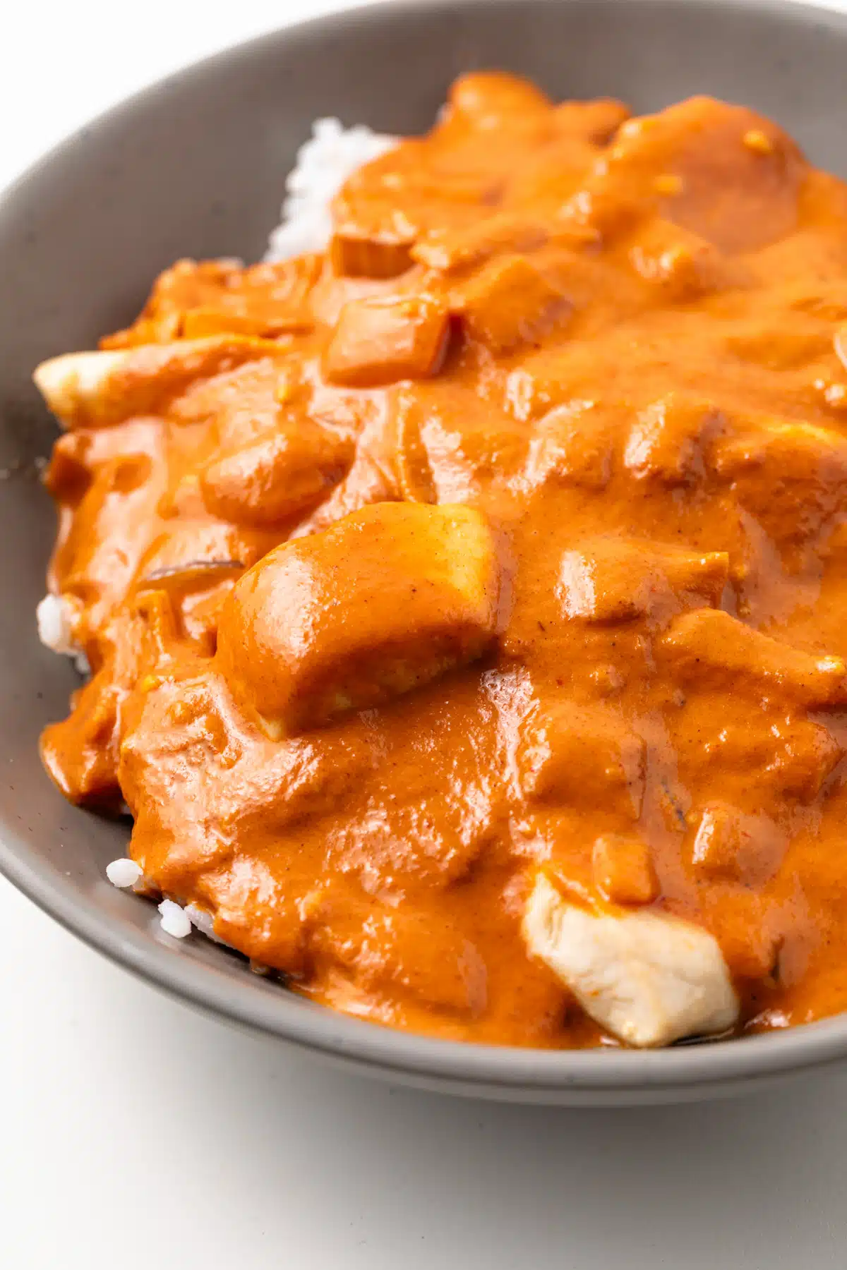 Close up of tikka masala sauce over rice in a bowl.
