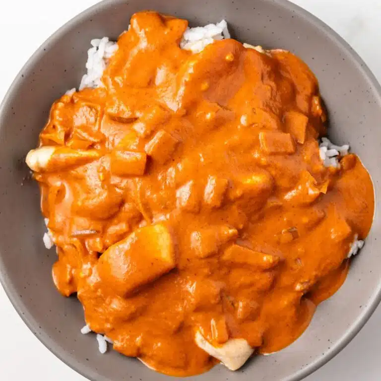 Overhead of tikka masala sauce over chicken and rice.