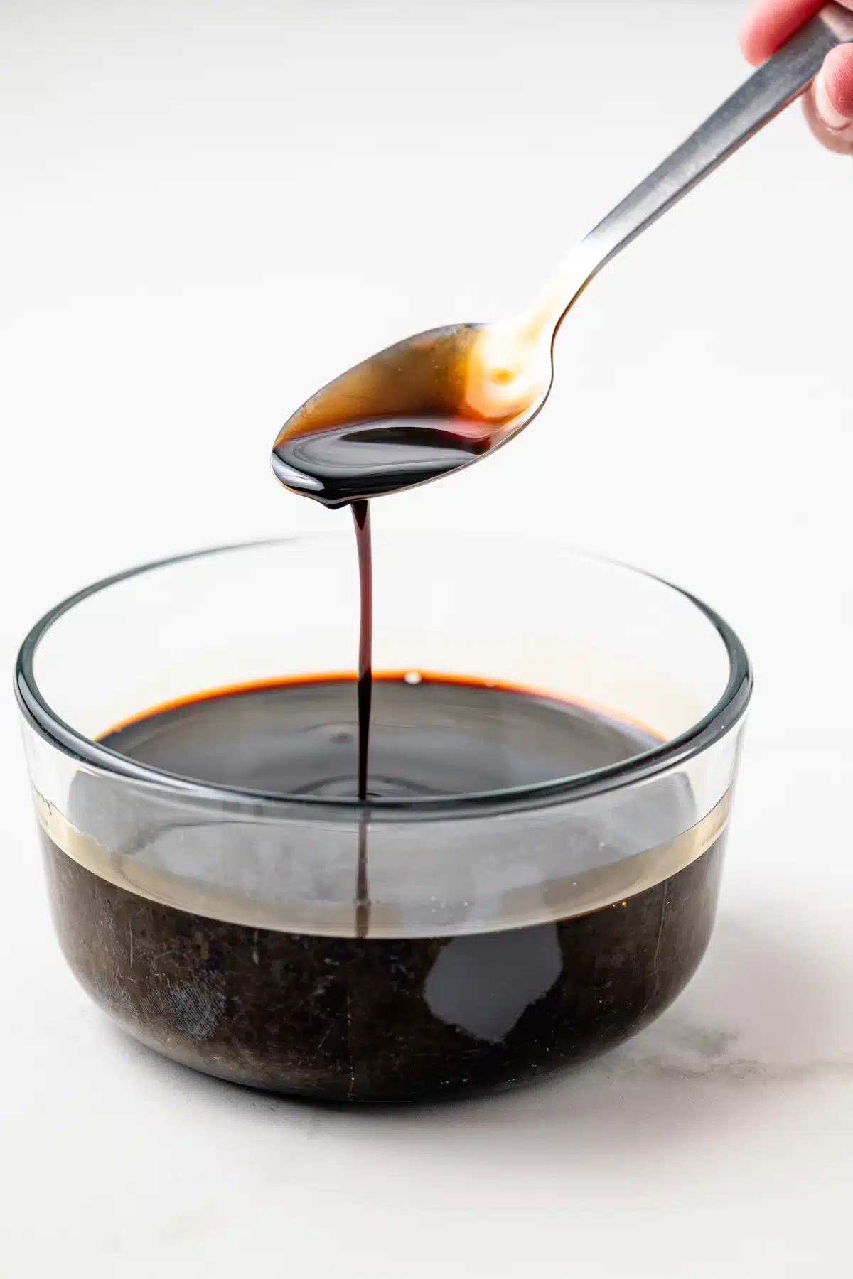 Balsamic glaze dripping off a spoon.