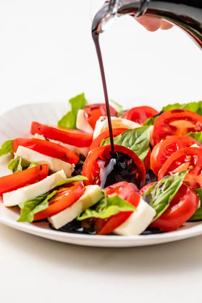 Balsamic glaze drizzled over caprese salad.