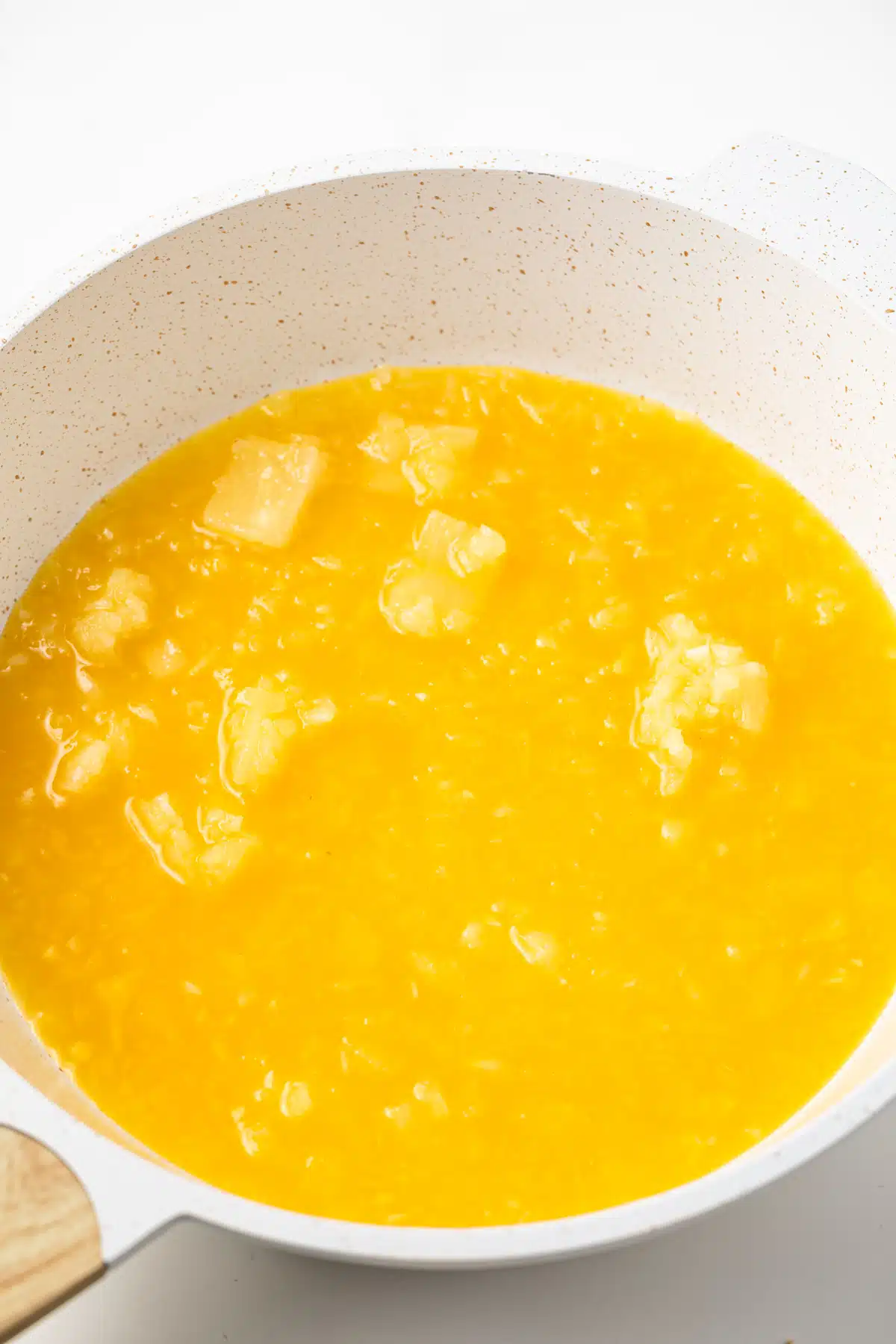 Pineapple and pineapple juice in a saucepan.
