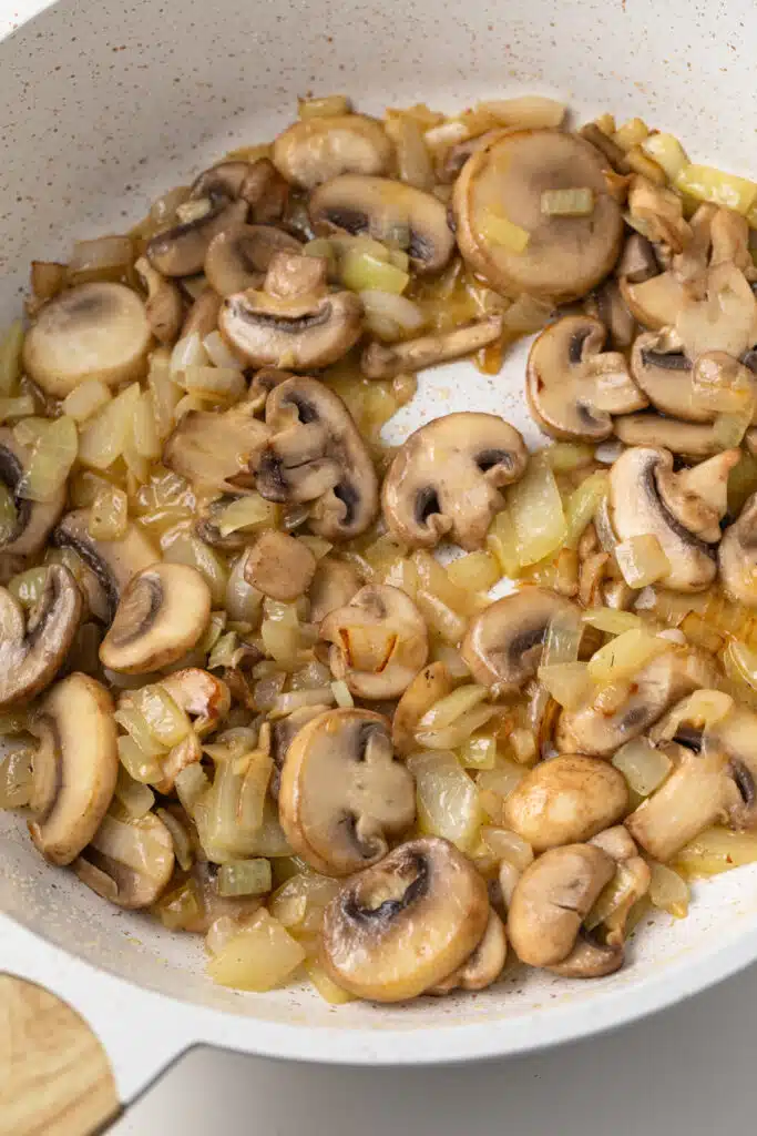 Sauteed mushrooms, onions, and garlic in a pan.