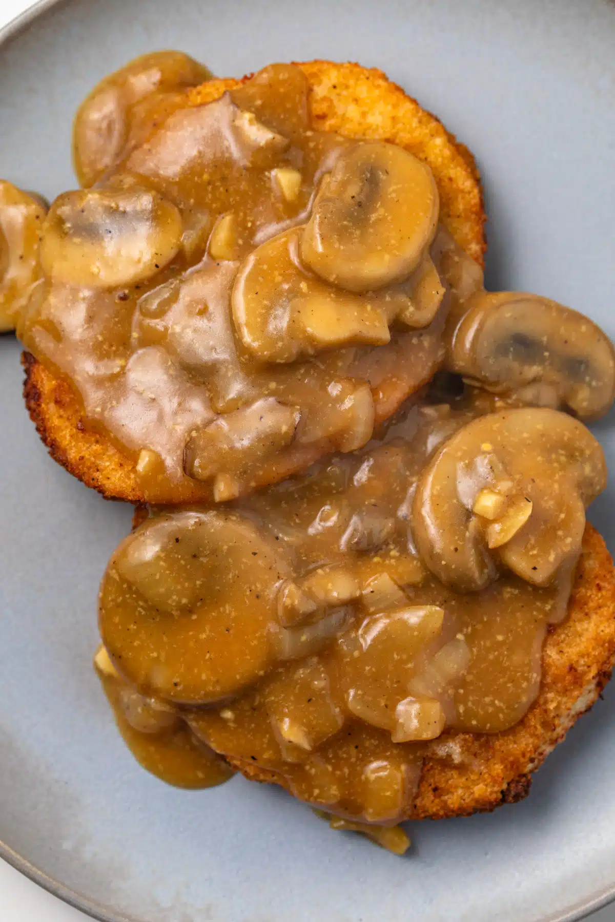 Overhead of mushroom sauce over schnitzel.