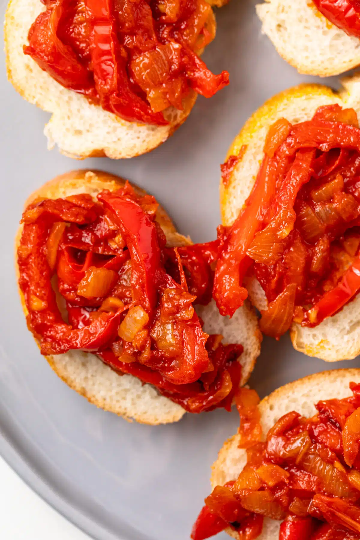 Overhead of peperonata on bread slices.