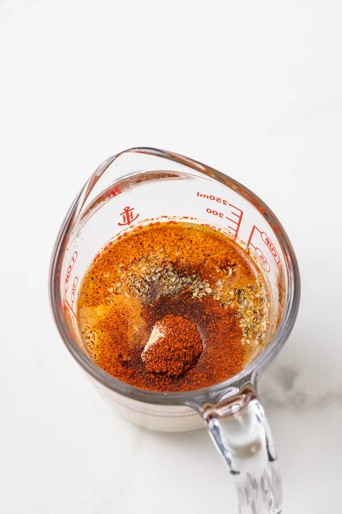 Ingredients for fajita sauce in a glass measuring cup.