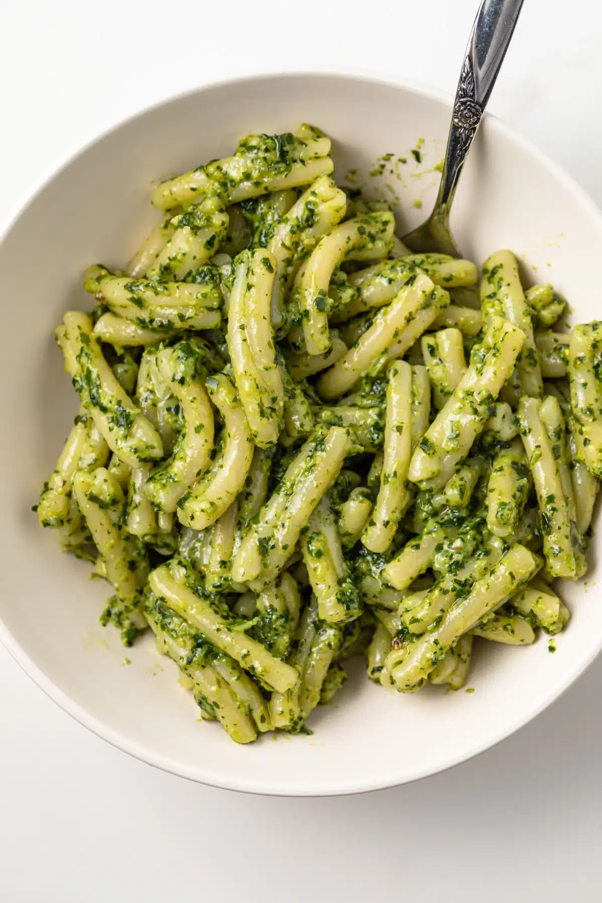 Pesto genovese over pasta in a bowl.