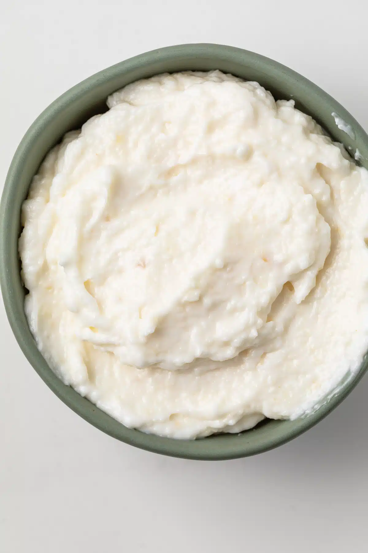 Lebanese garlic sauce in a green bowl.