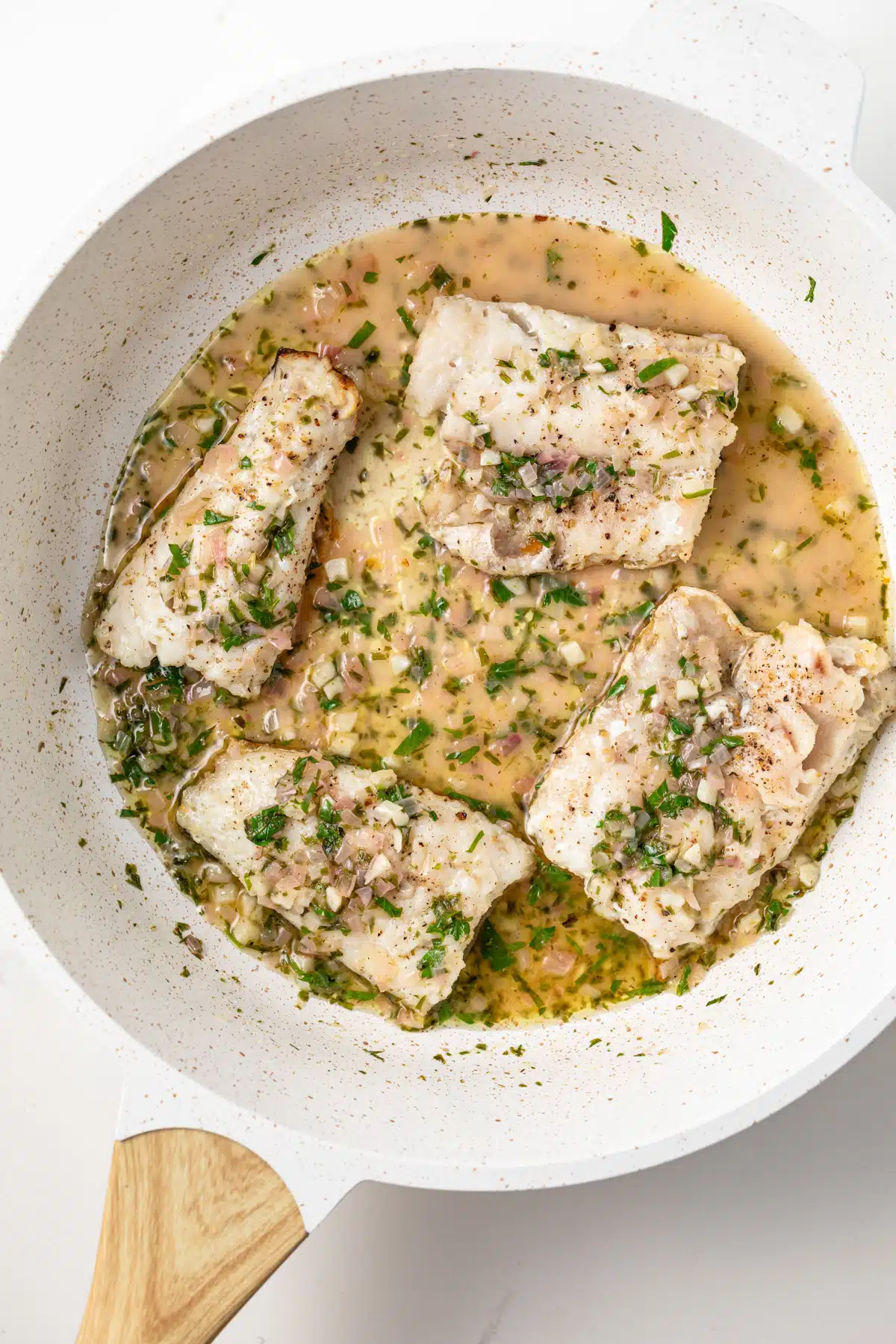 Classic pan sauce for fish in a skillet with fish filets.