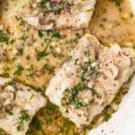 Close up of fish in pan sauce.