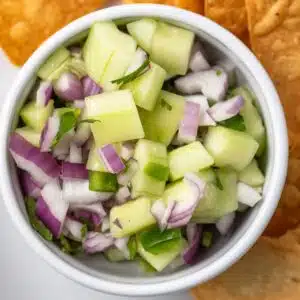 Overhead view of cucumber jalapeno salsa in a white bowl.