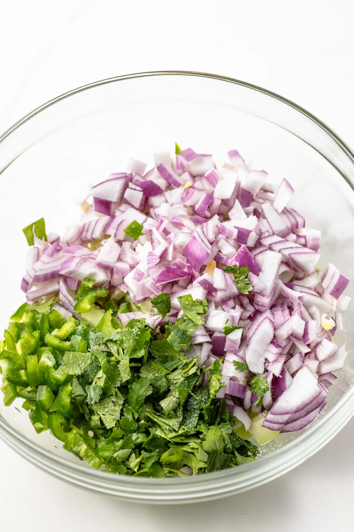 Ingredients for the salsa in a glass bowl.
