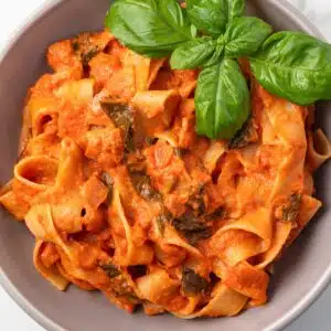 Tomato basil cream sauce over pasta in a bowl.