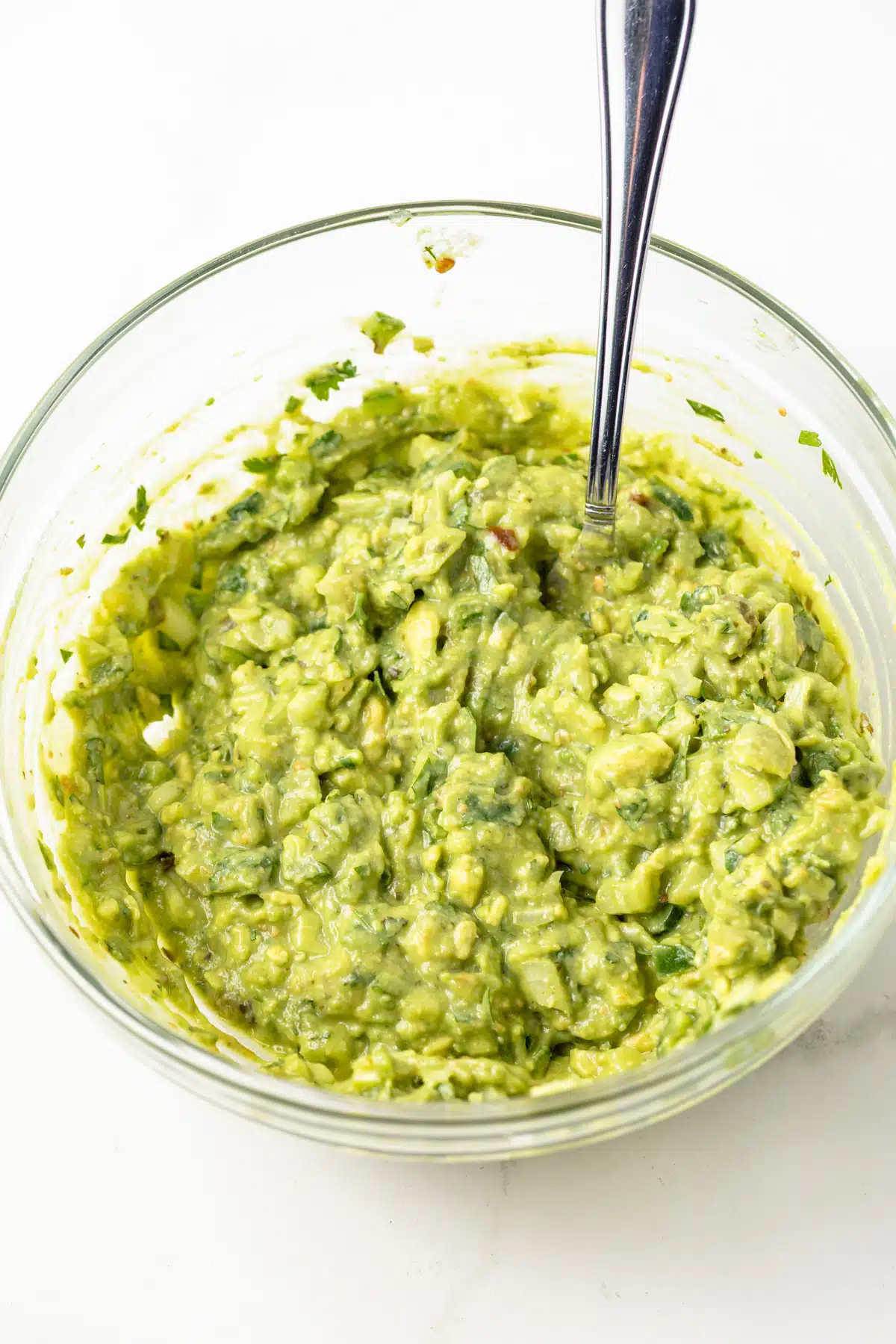 Salsa verde guacamole in a glass bowl.