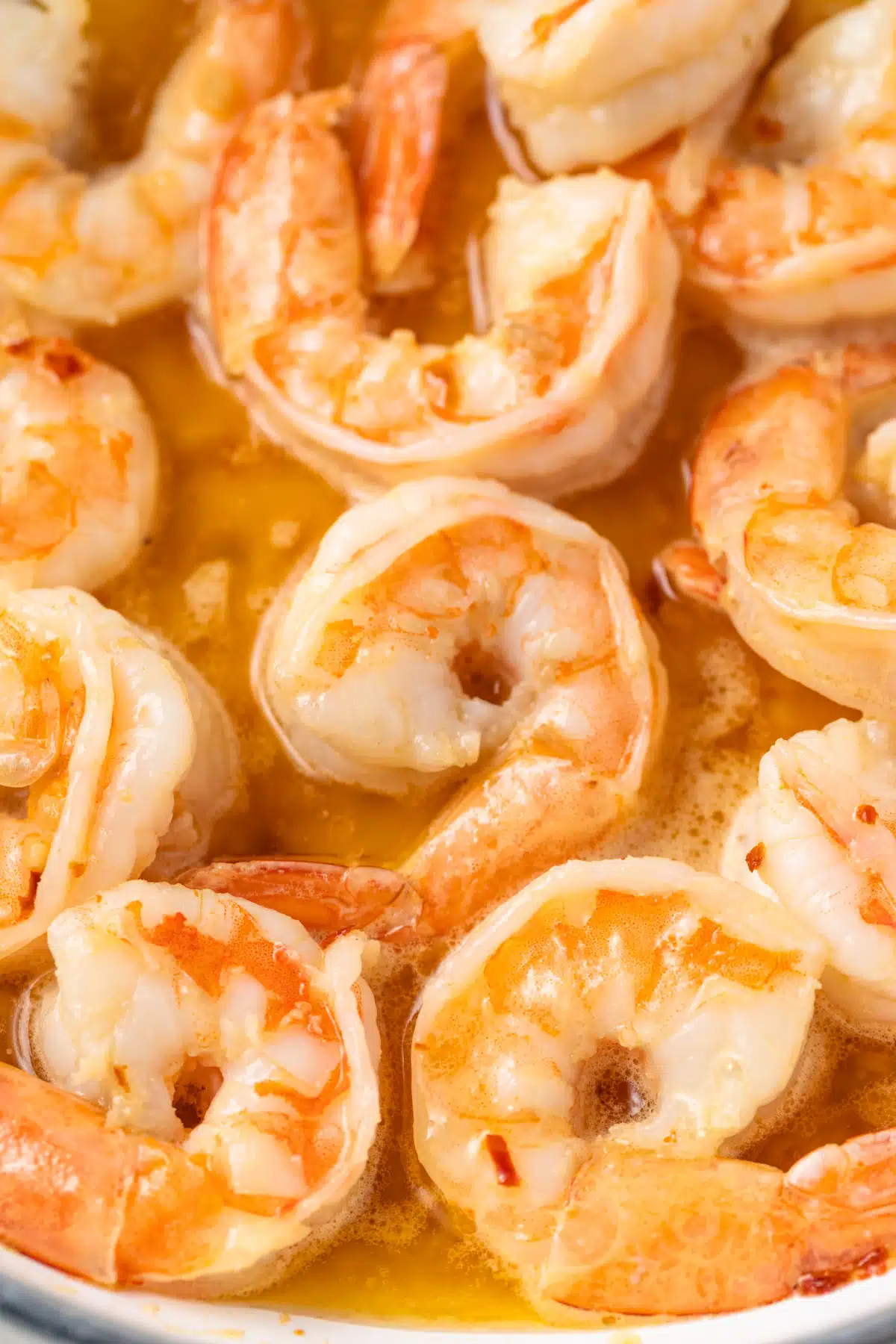 Close up of shrimp coated in scampi sauce.