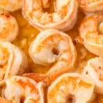 Close up of shrimp coated in scampi sauce.