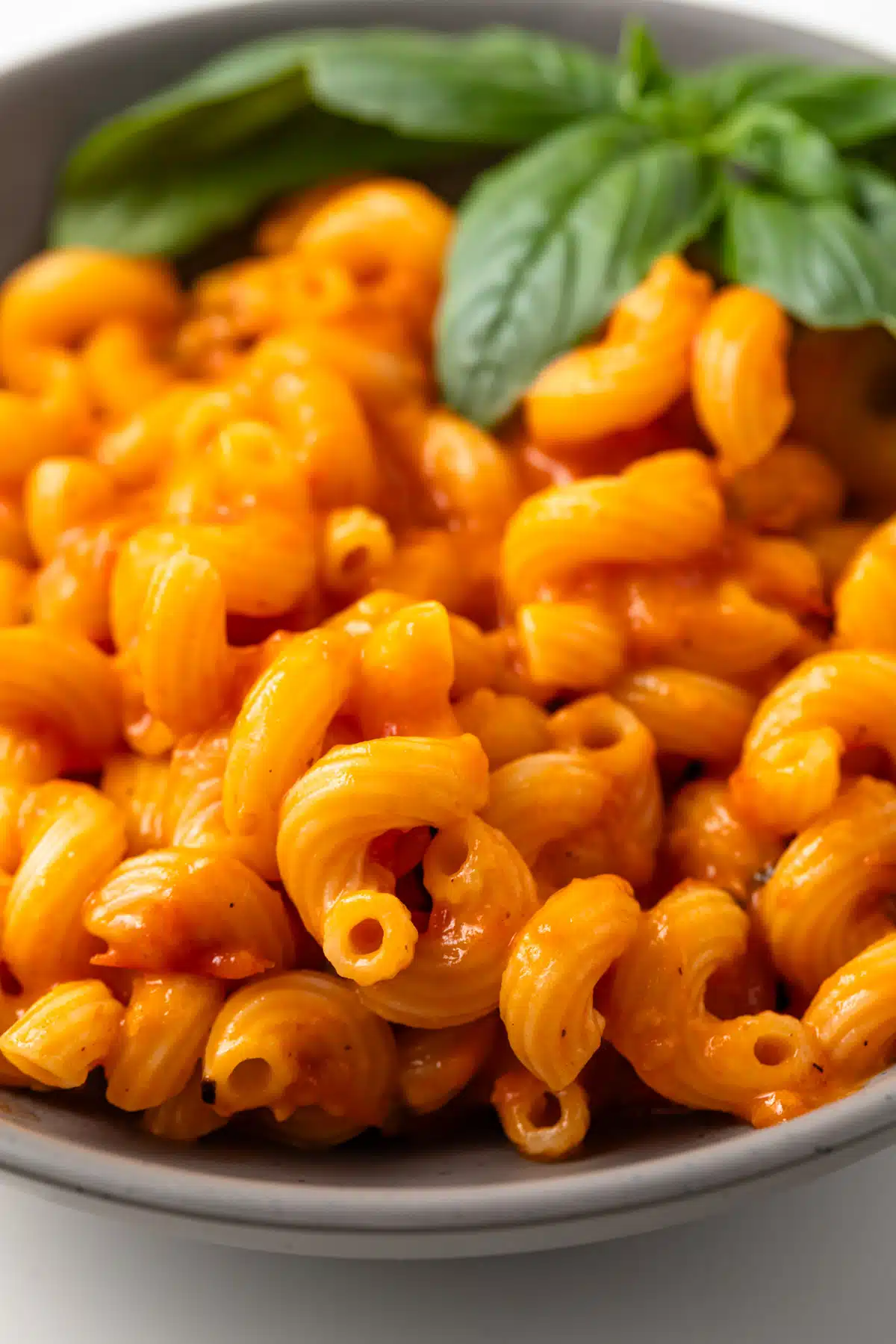 Roasted cherry tomato sauce over pasta in a bowl.